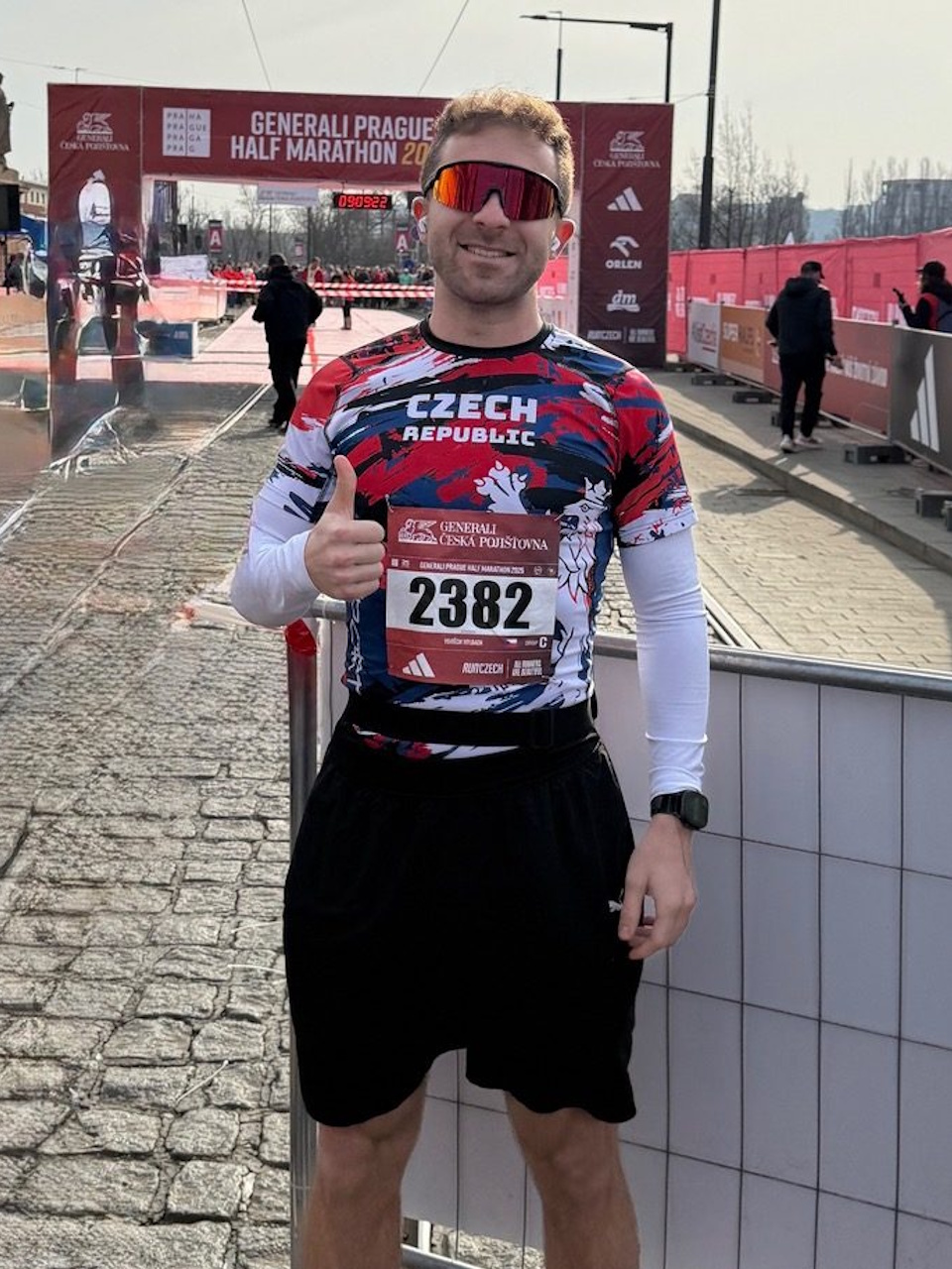 Ein Läufer mit Startnummer und Sportbrille vor dem Zielbereich des Rennens